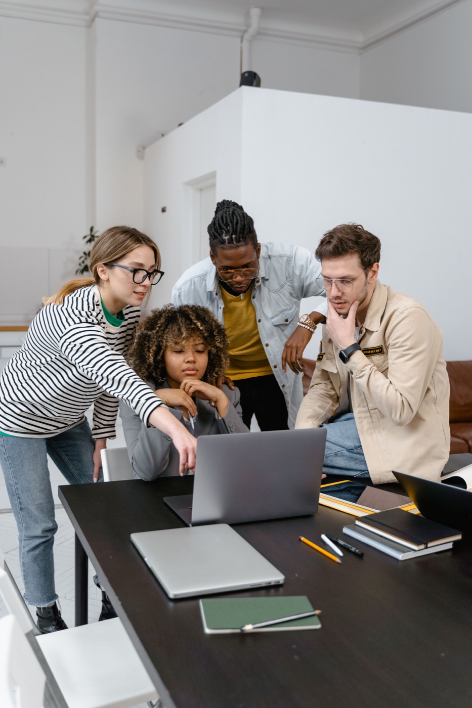 A team reviewing work together on a laptop